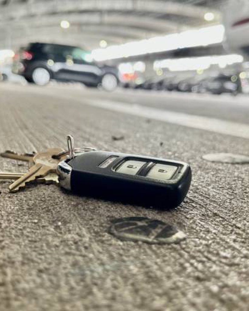 Keys on the concrete floor of a parking structure. They keys appear dropped and left behind.